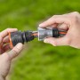Hände verbinden Gardena Premium Schlauchverbinder mit Wasserstop an Gartenschlauch.