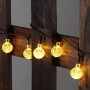 Salcar Solar LED Lichterkette mit 40 warmweißen Kristalllampen auf dunklem Holz. Ideal für Außen-Dekoration.