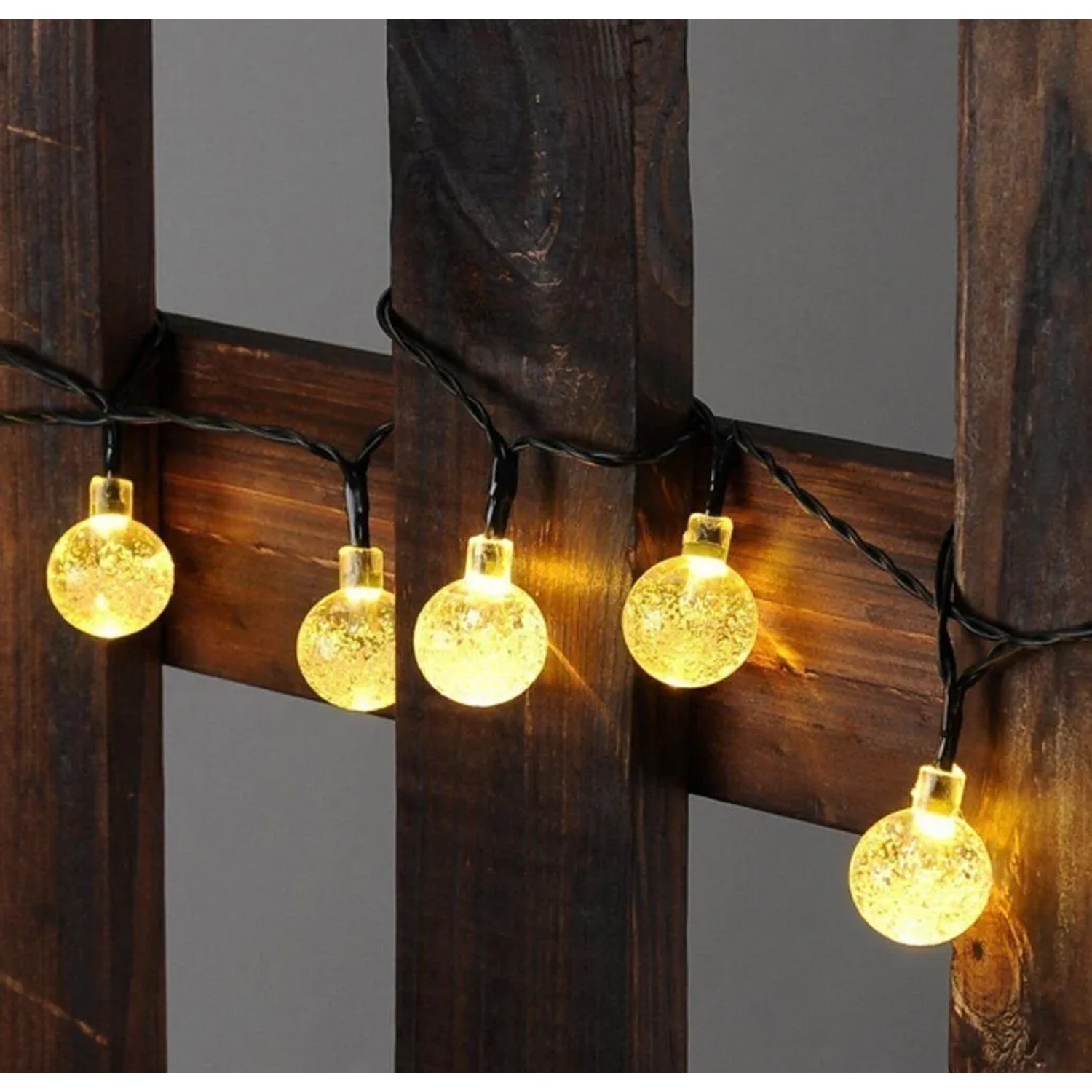 Salcar Solar LED Lichterkette mit 40 warmweißen Kristalllampen auf dunklem Holz. Ideal für Außen-Dekoration.