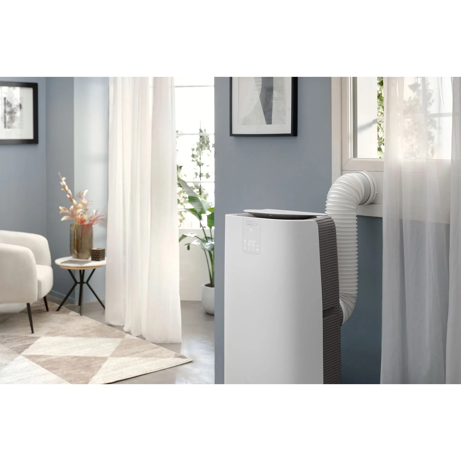 Weißes De'Longhi Klimagerät PAC-AP140i mit Abluftschlauch in modernem Wohnraum.