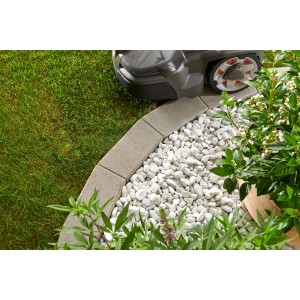 Graue Kann Mähkante Vigneto als Rasenkante mit Mähroboter und weißen Ziersteinen im Garten.