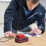 Einhell USB-Akku-Adapter TC-CP 18 Li USB A/C-Solo mit Akku und Smartphone beim Laden.