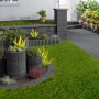 Anthrazit Gartenmauer aus Beton mit Bepflanzung als Grundstückseinfassung.