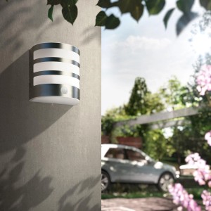 Moderne LED-Außenwandleuchte Calgary aus Edelstahl mit Bewegungsmelder an grauer Wand.
