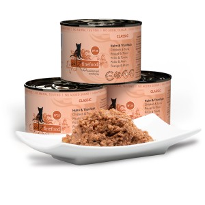 Drei Dosen Catz Finefood Katzenfutter Huhn und Thunfisch, davon eine geöffnet auf einem Teller.