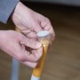 Anbringen einer transparenten Stuhlbeinkappe mit Filzgleiter zum Schutz des Bodens.