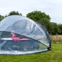 Exit Poolabdeckung ECO Ø 550 cm auf Rasen, transparente Kuppel schützt Pool mit Flamingo.