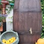 Dunkelbraune Arves Regentonne Barrique 250 l in Holzfass-Optik mit Wasserhahn und Dekoration.