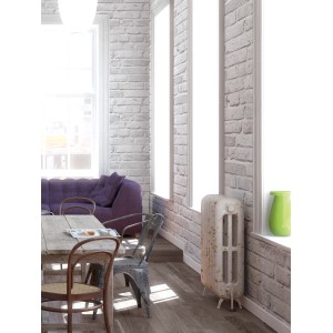 A.S. Creation Vliestapete Ziegelstein Mauer Grau im Wohnraum mit lila Sofa und Holztisch.