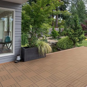 Verlegte Home Deluxe WPC-Fliesen Bavaro Teak auf einer Terrasse im Garten.