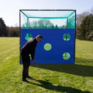 Golfkäfig-Netz mit Zielscheibe im Garten, Golfer beim Üben des Abschlags.