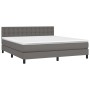 Graues Boxspringbett 180x200 cm mit Kunstlederbezug, inklusive Matratze und Kopfteil.