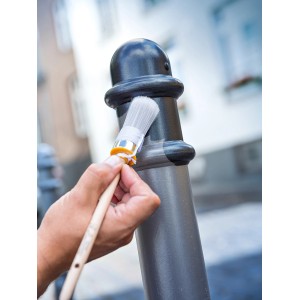 Lackierarbeiten mit LUX Ringpinsel Gr. 6: Ein Pinsel mit Holzgriff wird zum Lackieren eines Metallpfostens verwendet.