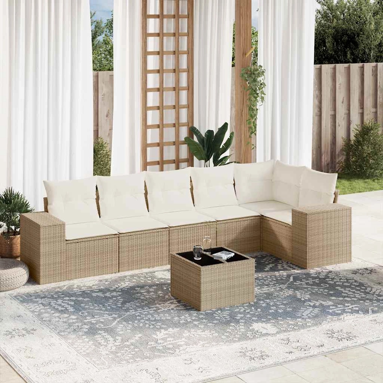 Beige 7-tlg. Garten-Sofagarnitur aus Rattan mit cremeweißen Kissen und Tisch mit Glasplatte.