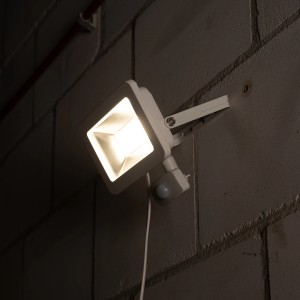 Weißer LED-Außenstrahler mit Sensor, 30W, 4000K, an grauer Wand montiert.