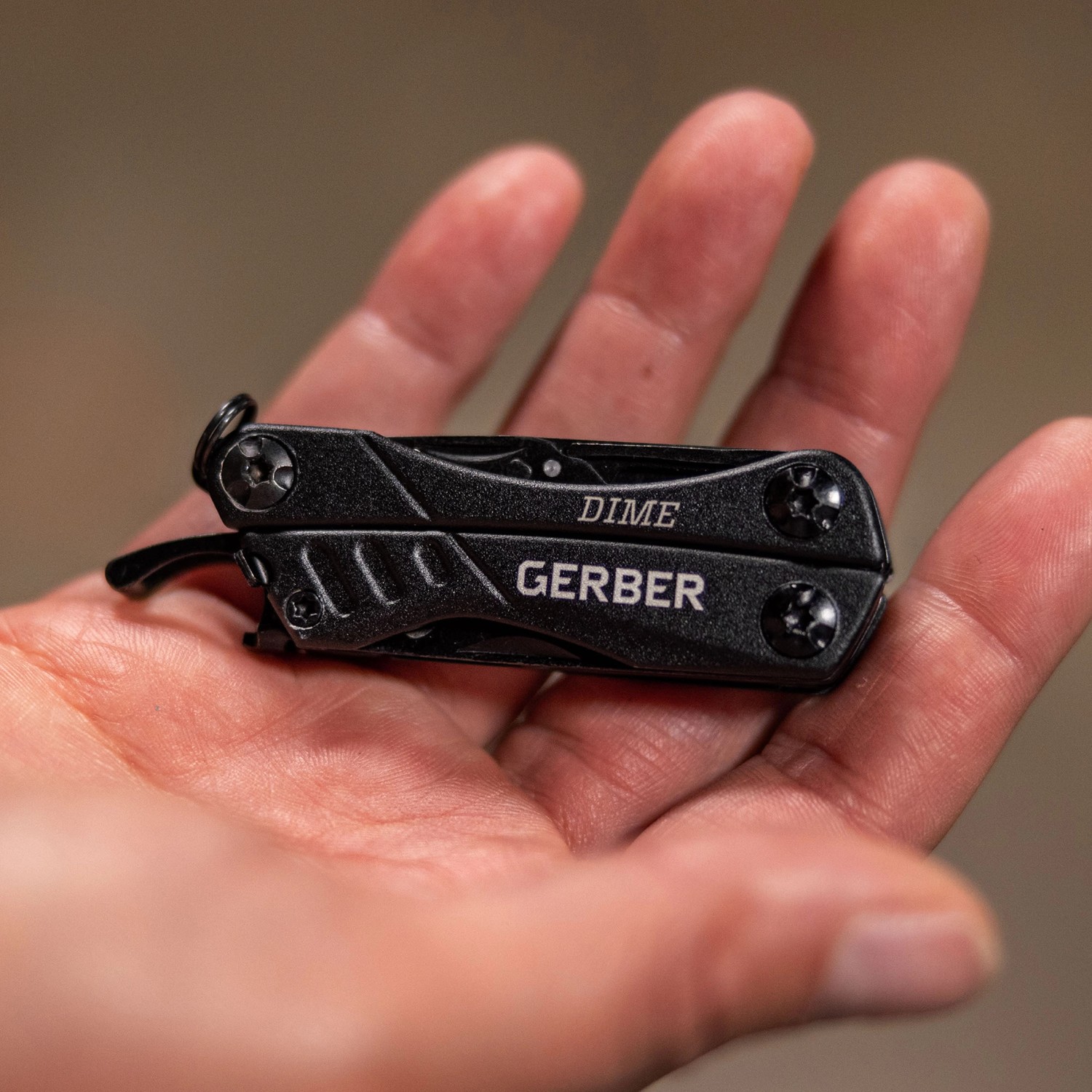 Schwarzes Gerber Multi-Tool Dime mit 12 Werkzeugen in einer Hand, geschlossen.