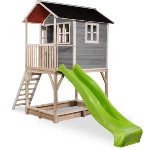 Graues EXIT Loft 700 Holzspielhaus mit grüner Rutsche, Sandkasten und Leiter.