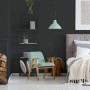 Schwarze Vliestapete Uni im Schlafzimmer mit mintfarbenem Sessel und Lampe.