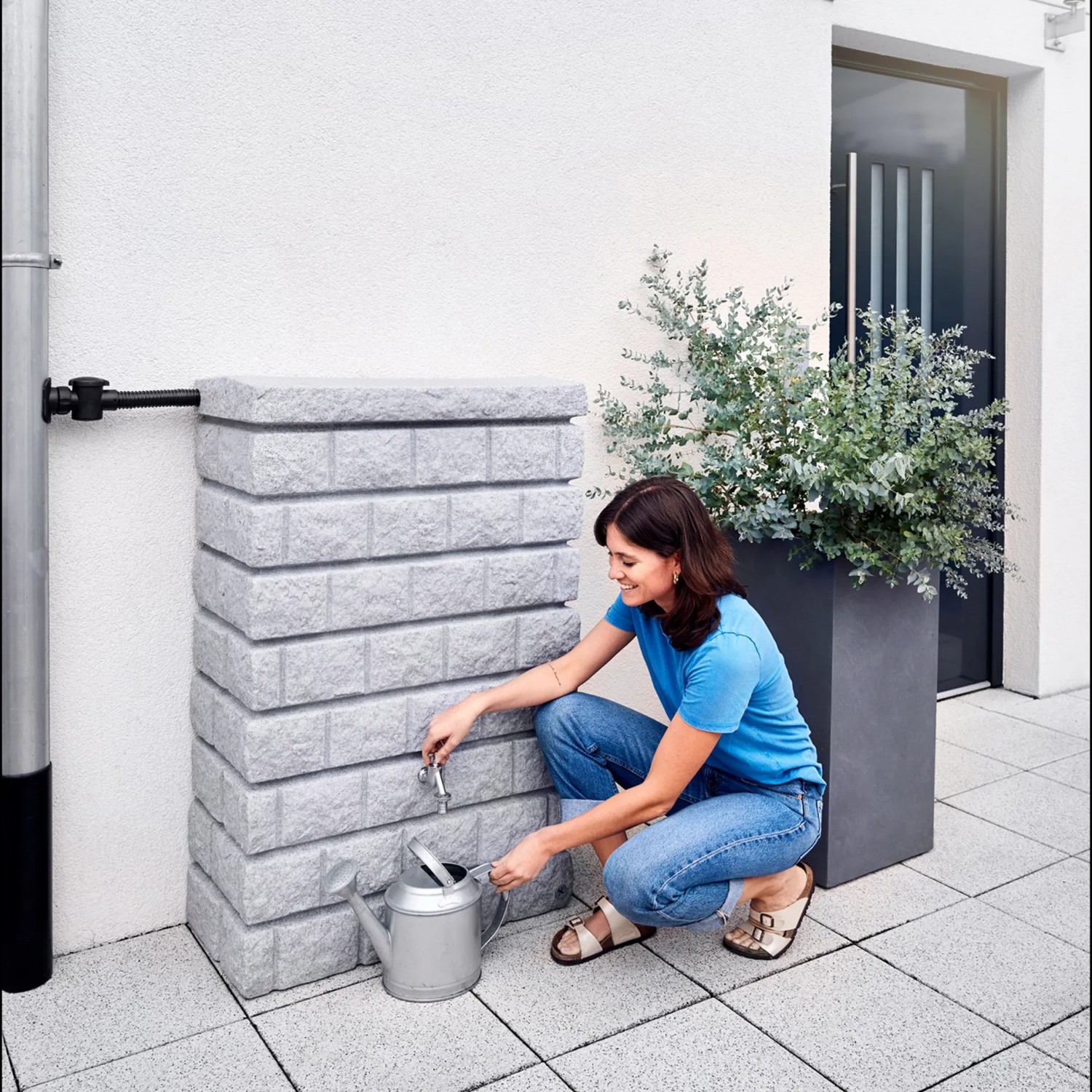 Garantia Wandtank Rocky Junior 300 l Light Granite mit Frau und Gießkanne.