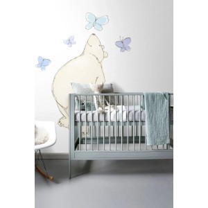 Kinderzimmer mit Fototapete: Bär in Beige, Blau und Lila mit Schmetterlingen über einem Babybett.