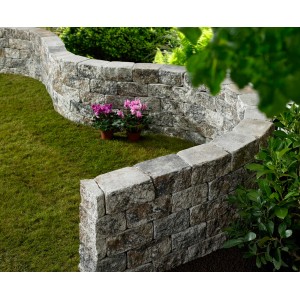 Geschwungene Mauer aus Vigneto Jura-Nuanciert Mauersteinen im Garten.