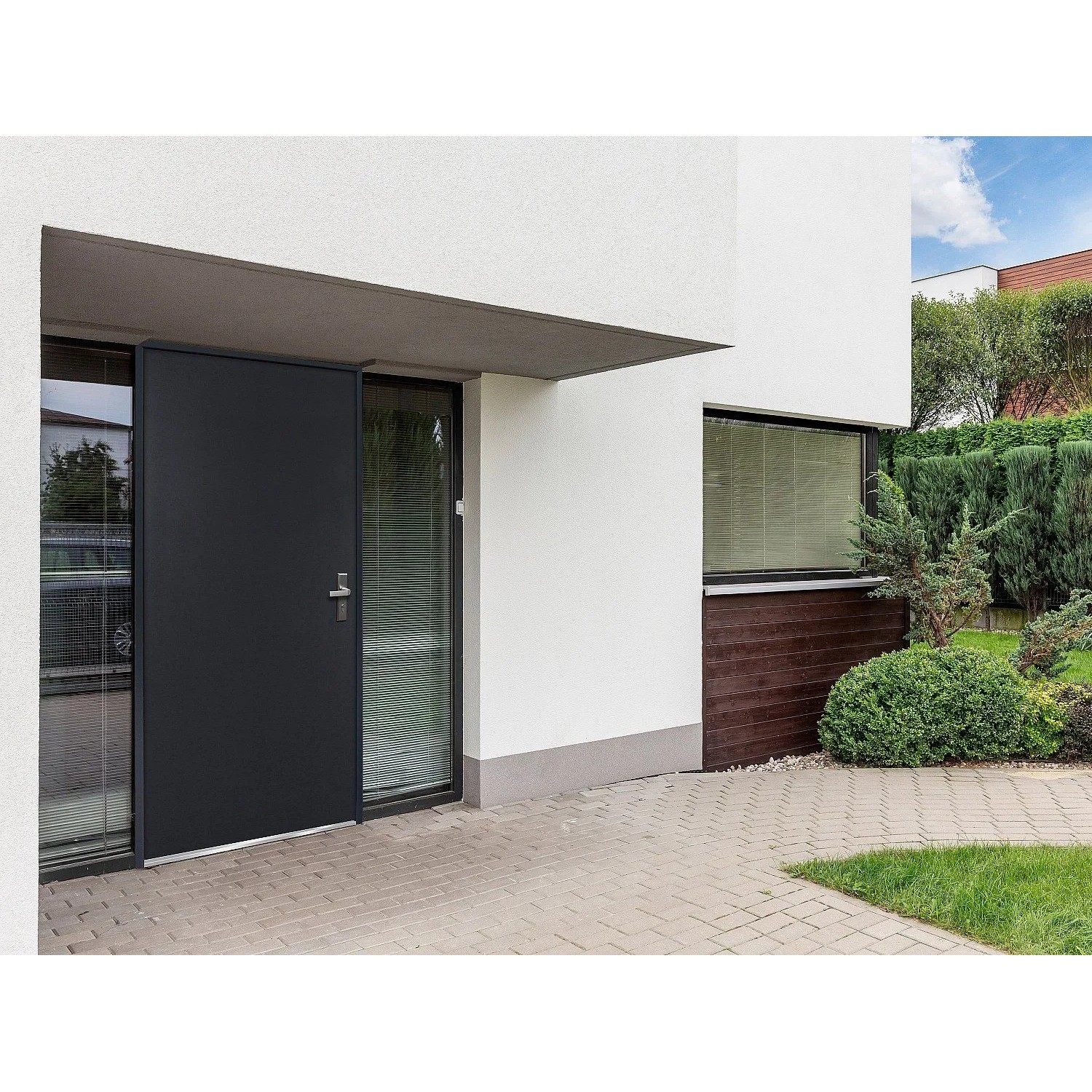 Anthrazitgraue Vente-unique Agueda Haustür aus Stahl, links angeschlagen, an modernem Haus mit Glas.