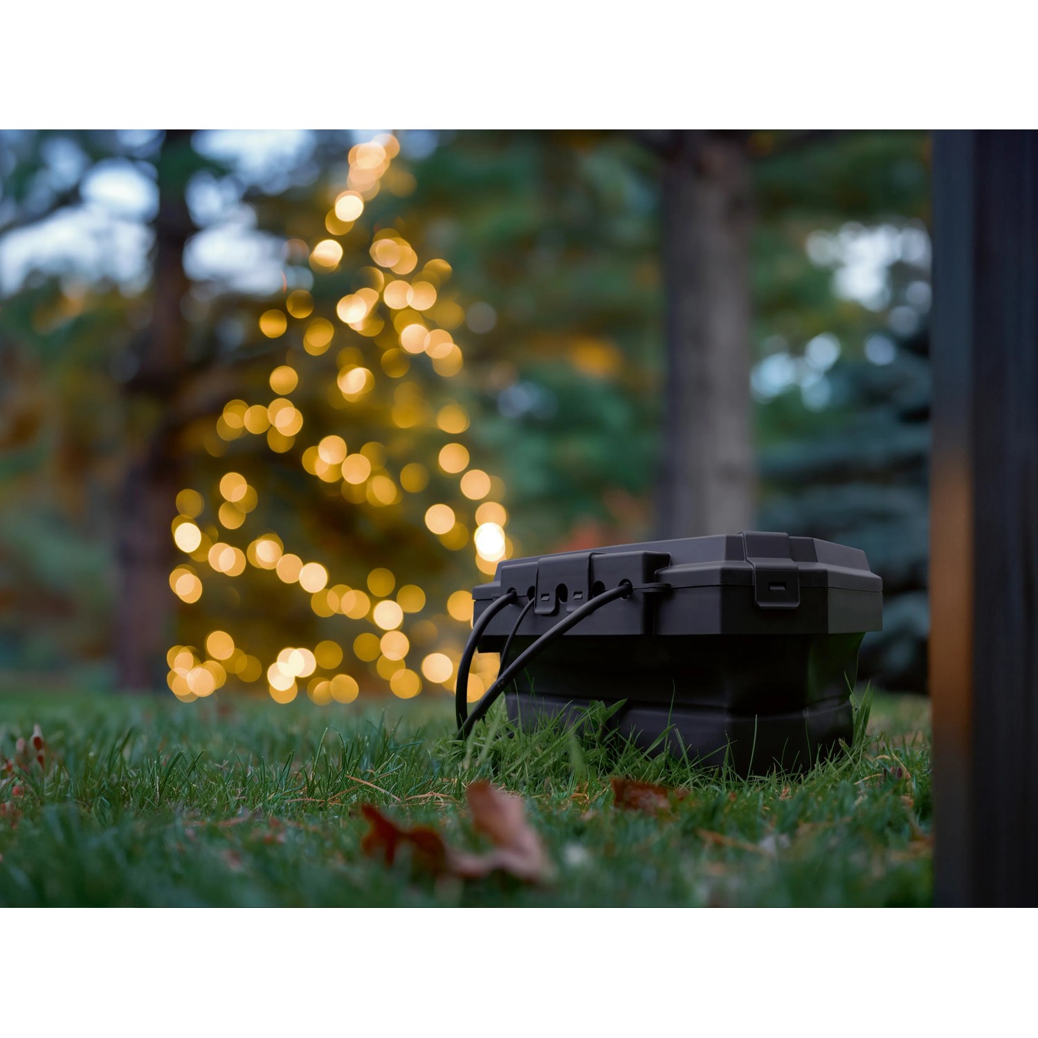 D-Line Wetterschutzbox, faltbar, mit 3 Steckdosen und Kabel im Garten, ideal für Weihnachtsbeleuchtung.
