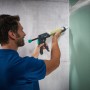 Mann benutzt wolfcraft Kartuschenpresse MG 600 Pro für Dichtstoff auf Wand.