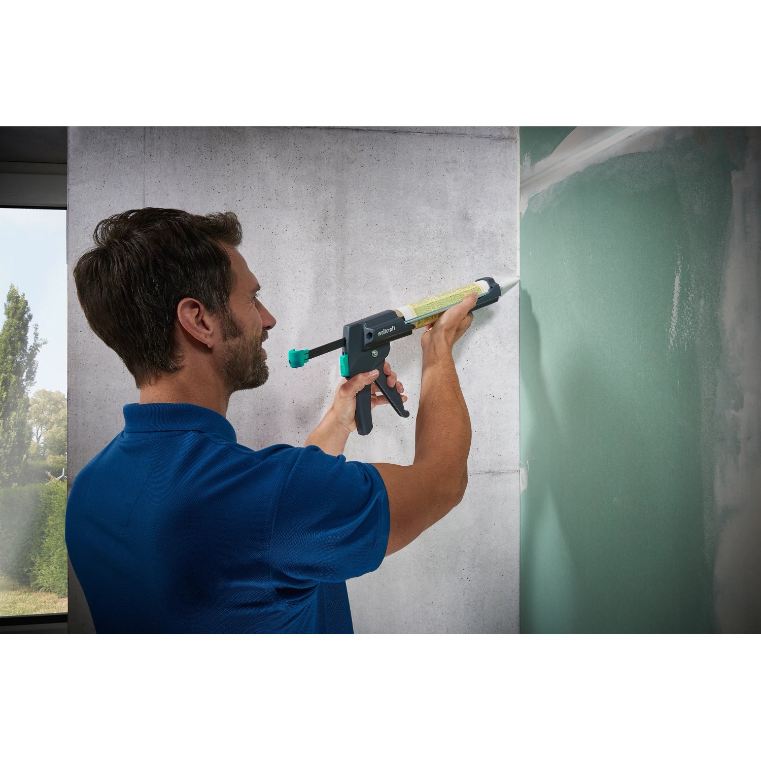 Mann benutzt wolfcraft Kartuschenpresse MG 600 Pro für Dichtstoff auf Wand.