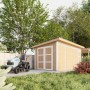 Grundiertes Timbela Holz-Gartenhaus M905C mit Rasentraktor im Garten.