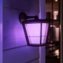 Hängende Philips Hue Econic LED-Laterne in Schwarz mit violetter Beleuchtung an Hauswand.