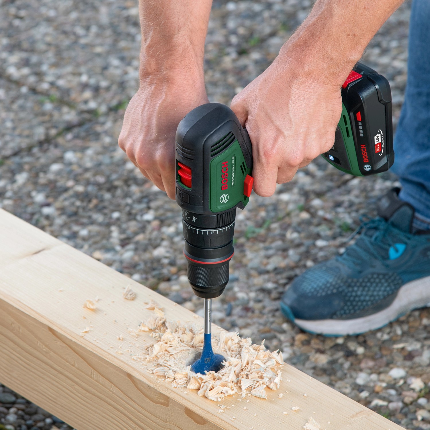 Bosch Advanced Drill 18V-80 Akku-Bohrschrauber beim Bohren in Holz. Kompakter, grüner Akkuschrauber mit Zusatzhandgriff.