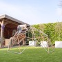 Exit Kletterkuppel Metal Climbing Dome Ø 300 cm im Garten mit Kind beim Klettern.