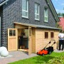 Karibu Holz-Gartenhaus Timsund, unbehandelt, mit Pultdach und geöffneten Türen. Rasenmäher im Vordergrund.