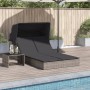 Graue Doppel-Sonnenliege mit Dach und Auflagen aus Poly Rattan neben Pool.