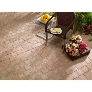Sandfarbene Etrusco Beton Pflastersteine (14x14x5 cm) auf Terrasse mit Gartenmöbeln.