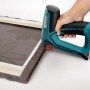 Novus Elektrotacker J-150 beim Befestigen von Stoff auf einem Holzrahmen.