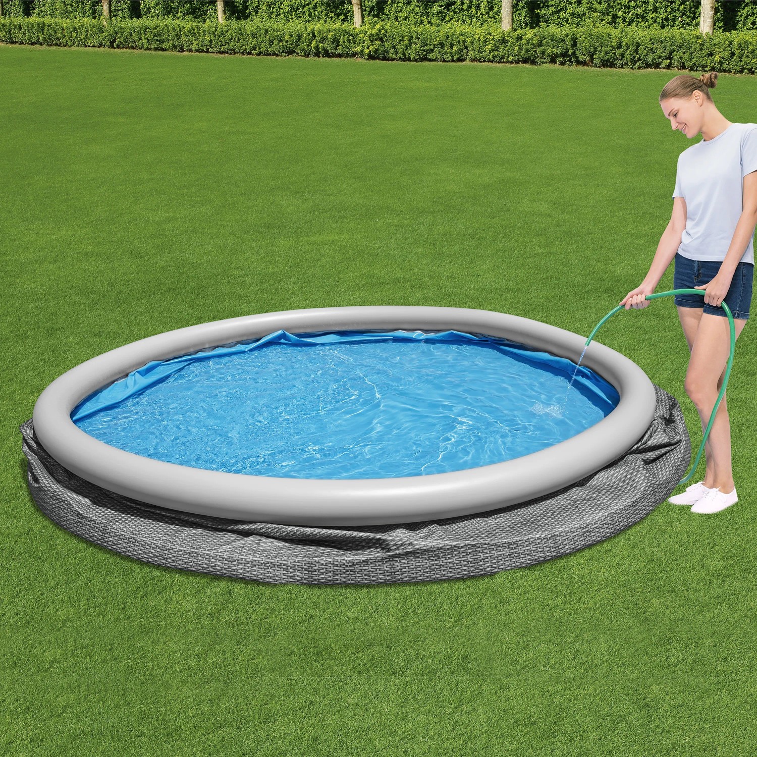 Bestway Fast Set Pool Ø 457 cm mit Luftring und Rattan-Optik, wird mit Wasser befüllt.