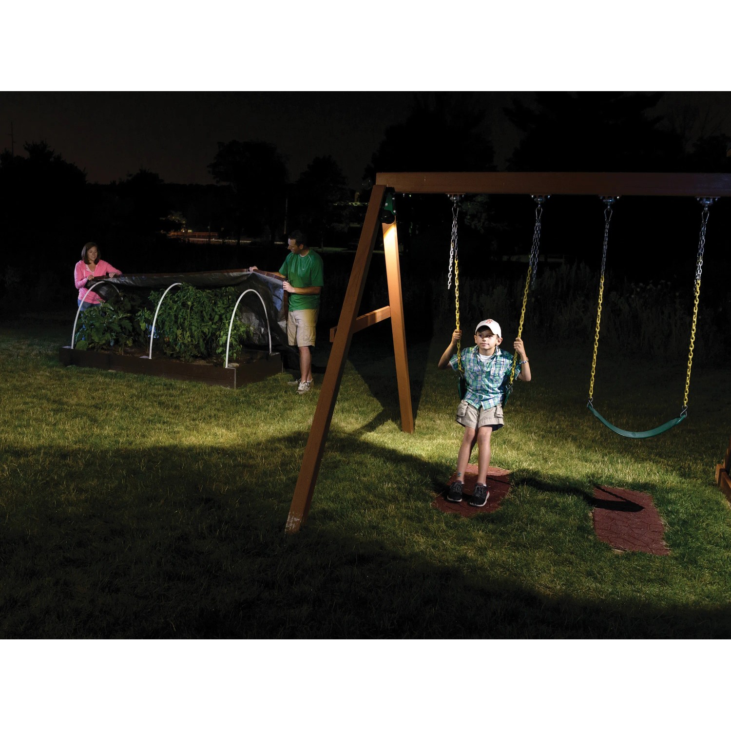 Mr. Beams LED-Außenwandleuchte MB310 beleuchtet Garten mit Schaukel und spielendem Kind.