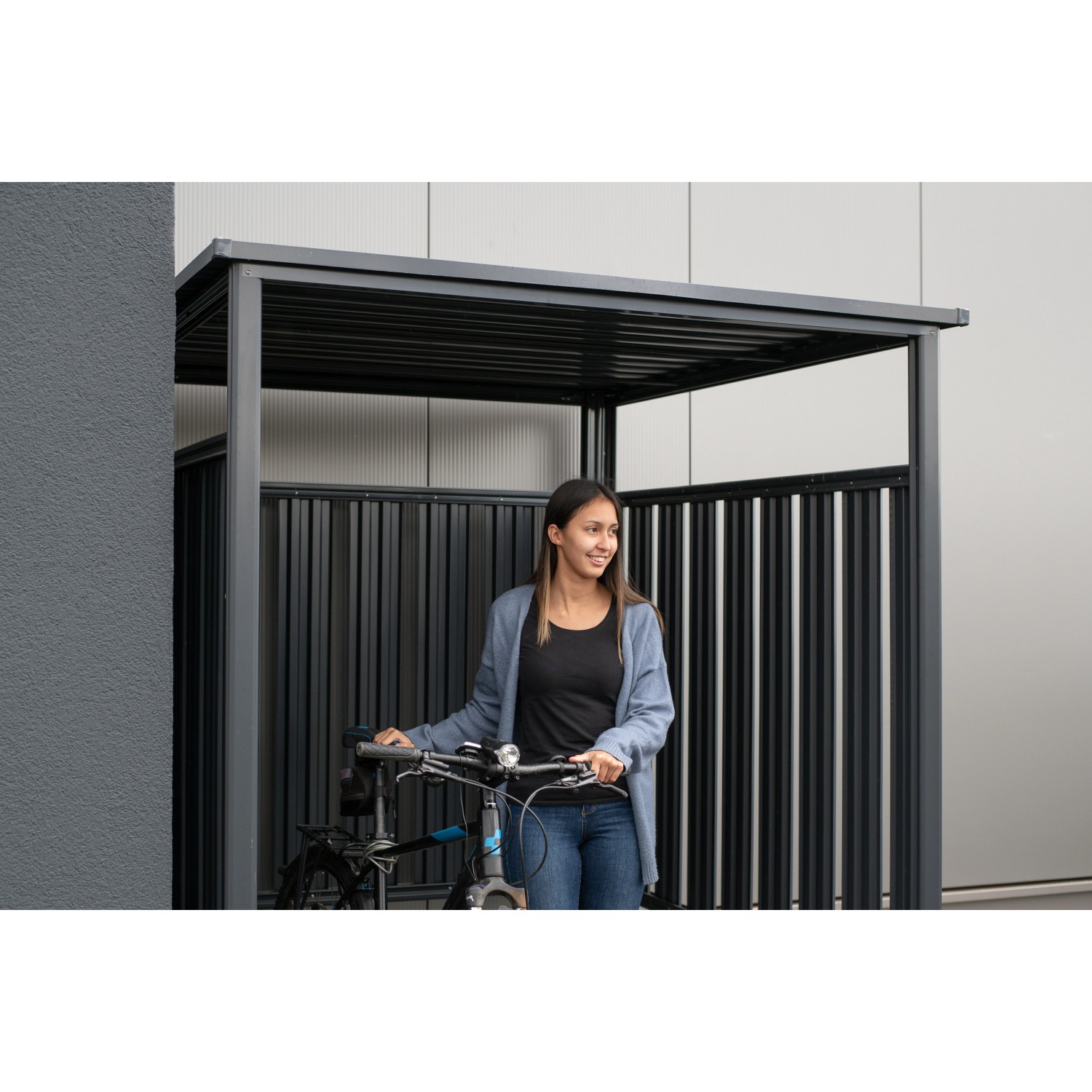 Anthrazitfarbener Westmann Fahrradunterstand mit Frau und Fahrrad. Ideal als Terrassenüberdachung.