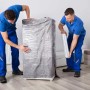 Zwei Männer verpacken Möbel mit Primaflor Möbelpackdecke und Folie für den Umzug.
