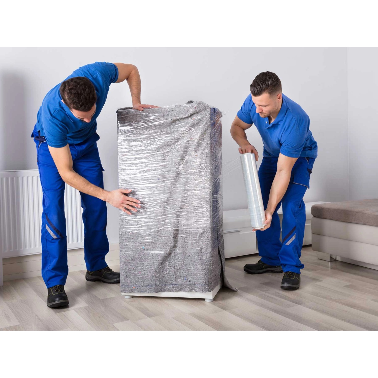 Zwei Männer verpacken Möbel mit Primaflor Möbelpackdecke und Folie für den Umzug.