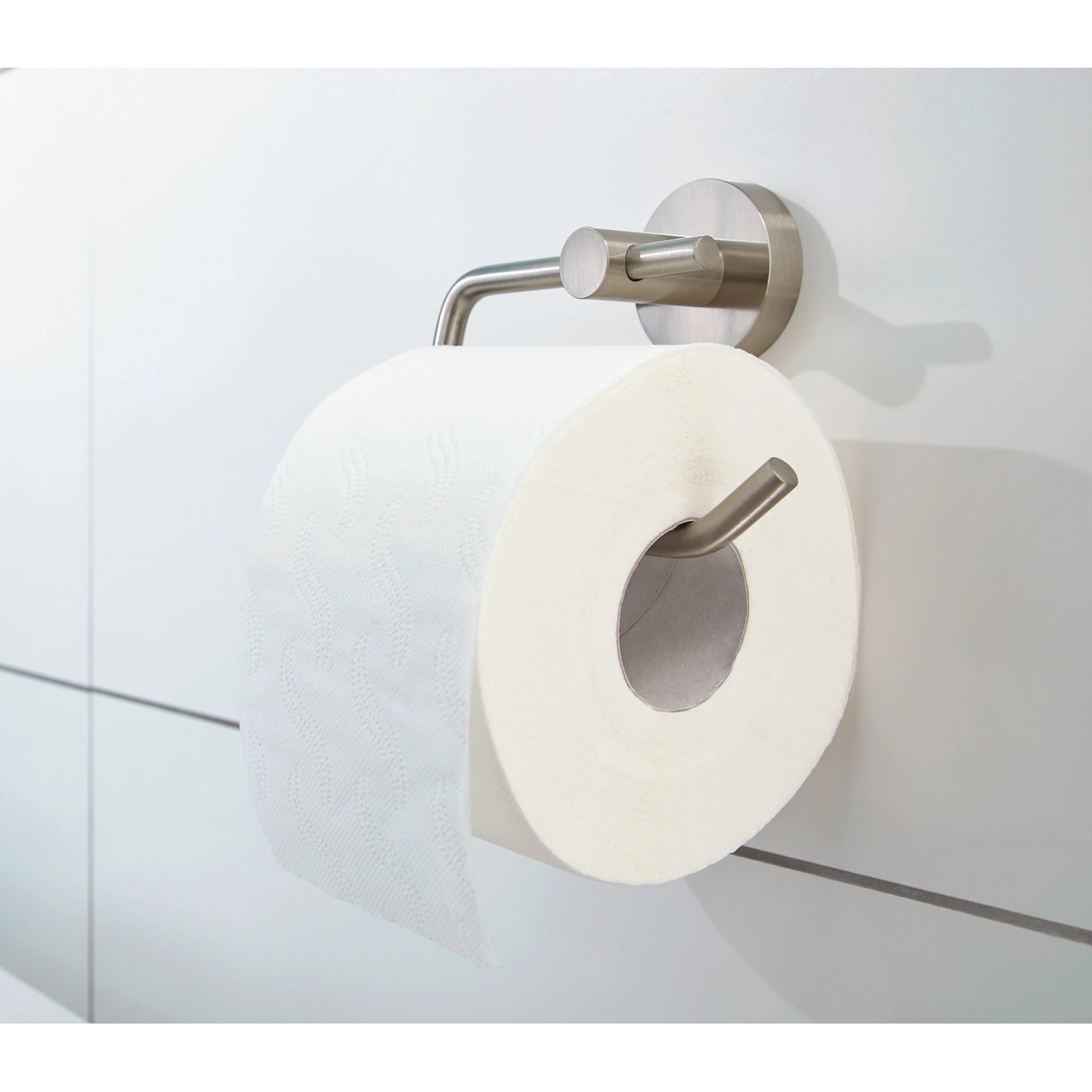 Tesa Toilettenpapierhalter Moon in Edelstahloptik mit Papierrolle an weißer Wand.