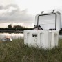 Petromax Kühlbox Sand 50L, geöffnet, am See. Ideal für Camping & Outdoor. Robuste Passiv-Kühlbox.