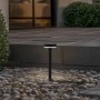Schwarze Lindby LED Solarleuchte Brinca mit Bewegungsmelder im Garten.