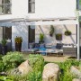 Weiße Skan Holz Terrassenüberdachung Novara 557x309 cm mit Sitzgruppe und Gartendeko.