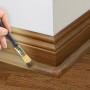 Holzfarbener D-Line Kabelkanal (22x22mm) mit Pinsel an einer Ecke gestrichen.