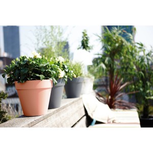 Elho Blumentopf Loft Urban, Ø 30 cm, Delicate Pink, mit Pflanzen auf einer Terrasse.