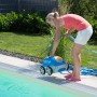 Frau bedient Steinbach Speedcleaner Poolrunner am Pool. Automatischer Poolsauger in Blau und Weiß.