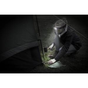 Frau beim Zeltaufbau mit Energizer Kopflampe Compact Sport Headlamp. Taschenlampe leuchtet.